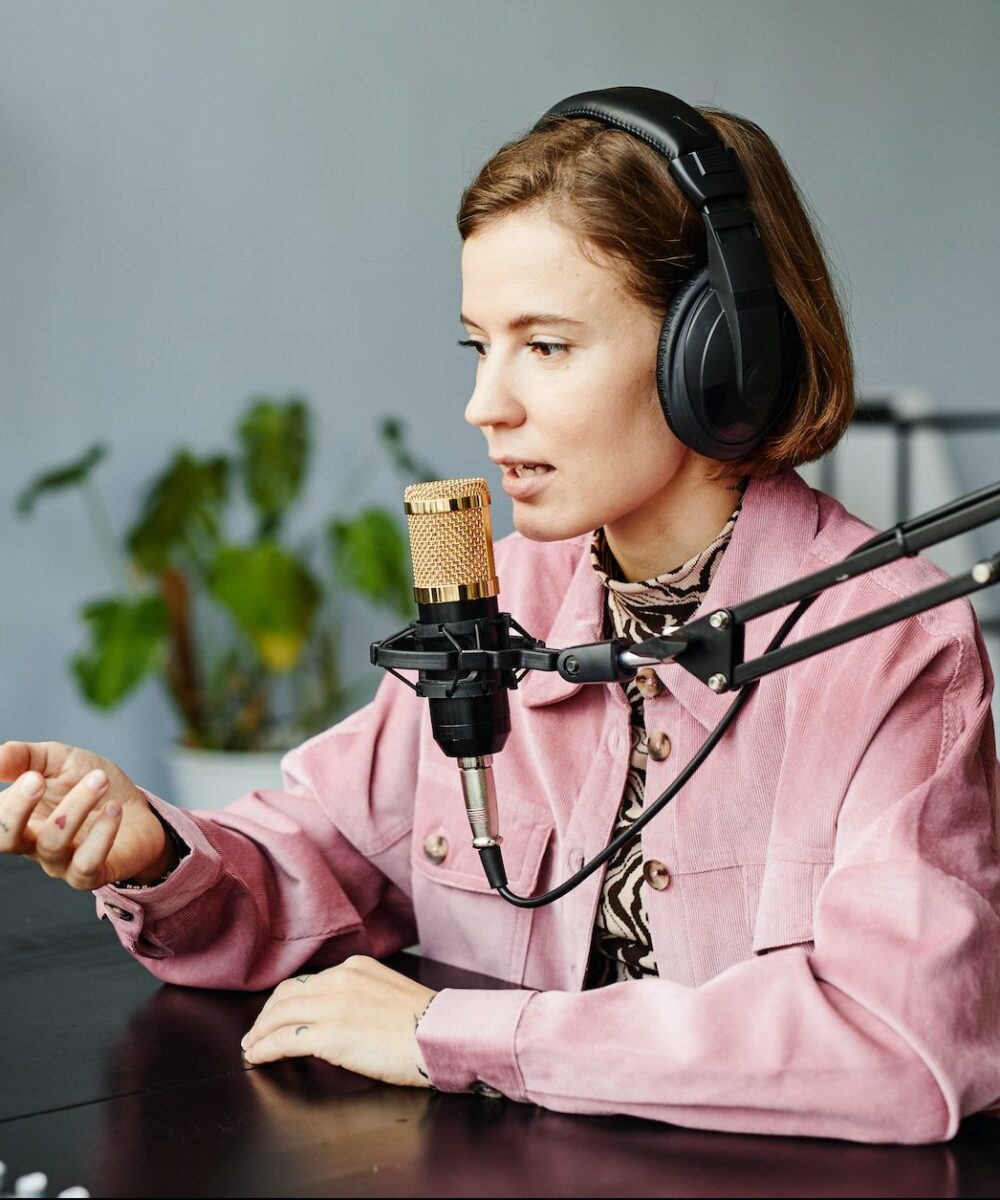 young-woman-recording-podcast-at-home-e1665506644614.jpg